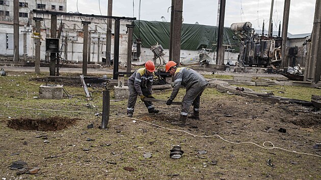 Pracovn�ci spole�nosti DTEK odkl�zej� trosky p�i oprav� rozvodny zni�en� p�i �toku rusk�ho dronu na nezn�m�m m�st� na Ukrajin�. (25. b�ezna 2025)