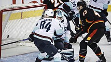 Adam Klapka z Calgary Flamws dorá�í puk za záda branká�e Joeyho Daccorda ze...