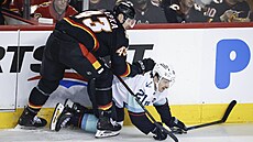 Adam Klapka z Calgary Flames a Mikey Eyssimont z Seattle Kraken bojují u...