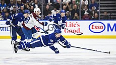Mitch Marner z Toronto Maple Leafs ská�e za pukem p�ed Nathanem MacKinnonem z...