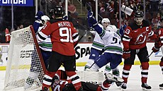 Skrumá� p�ed brankou New Jersey, v pozadí se z gólu raduje Pius Suter z...