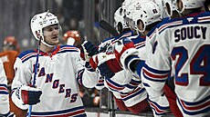 Obránce New York Rangers Adam Fox slaví se spoluhrái vstelenou branku bhem...