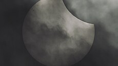 Detailní pohled na �áste�né zatm�ní Slunce p�es hustou obla�nost nad �eskem.