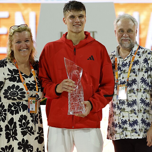 Jakub Men��k, obklopen sv�mi rodi�i, p�zuje s trofej� pro �ampiona turnaje v Miami.
