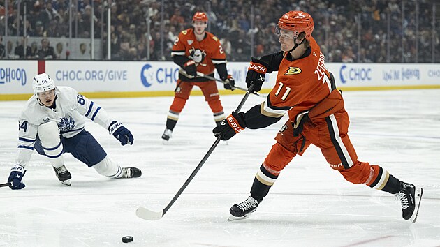 Trevor Zegras vym��l� akci, v pozad� zaklek�v� David K�mpf.