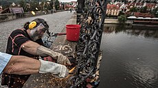 Roman Kotr� ze Sdru�ení výtvarník� Karlova mostu s roz�ezává úhlovou bruskou...