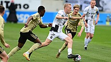 Hradecký obránce Karel Spáil se snaí prosmýknout mezi soupei z eských...
