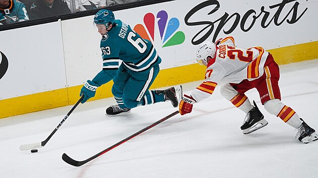 Zack Ostapchuk (vlevo) ze San Jose Sharks to v zpase s Calgary Flames, brn ho Matt Coronato.