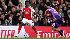Bukayo Saka (vlevo) z Arsenalu kouzlí s mí�em, napadá ho Antonee Robinson z...