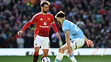 Bruno Fernandes z Manchesteru United si hlídá mí� v derby s Manchesterem City,...