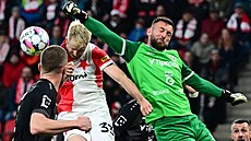 Královéhradecký brankář Adam Zadražil vyráží míč před slávistou Ondřejem...