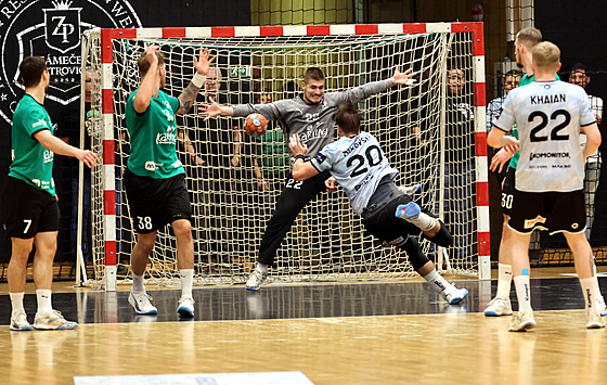 Karvinský branká� Vojt�ch Ko��álek se sna�í chytit st�elu lovosického Jaroslava...