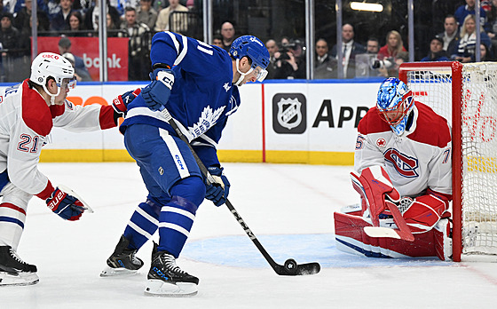 Branká� Montrealu Jakub Dobe� zasahuje proti �anci Johna Tavarese z Toronta.