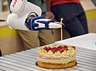 Robota naprogramovali, aby umisoval svky na dort.