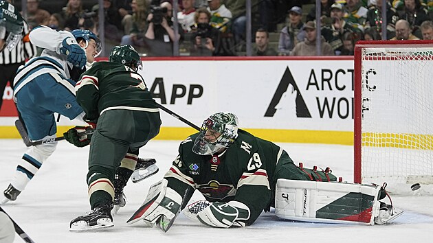 Macklin Celebrini ze San Jose Sharks p�ekon�v� v souboji obr�nce Minnesota Wild Brocka Fabera i brank��e Marca-Andr�ho Fleuryho.