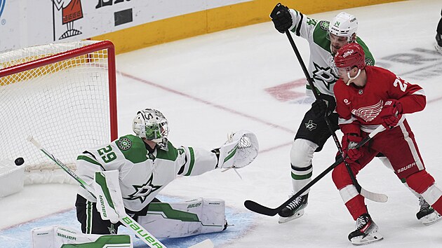 Lucas Raymond (23) z Detroit Red Wings sleduje puk let�c� do br�ny Dallas Stars kolem Jakea Oettingera (29).