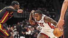 Davion Mitchell z Miami se zkou�í uvolnit p�es Carisa LeVerta z Atlanty.