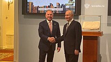 Ruský prezident Vladimir Putin si podává ruku se zvlá�tním vyslancem amerického...