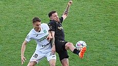 Slávistický útoník Vasil Kuej v souboji s karvinským záloníkem Momilem...