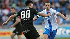 Zálo�ník Robert Hrubý z Bohemians se sna�í projít s mí�em mezi Tomá�em...