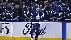 Auston Matthews slaví se st�ída�kou Toronta gól do sít� Detroitu.