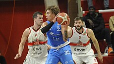 Noah Carter z Olomoucka u mí�e v zápase s Pardubicemi, hlídají ho Lubo� Ková�...