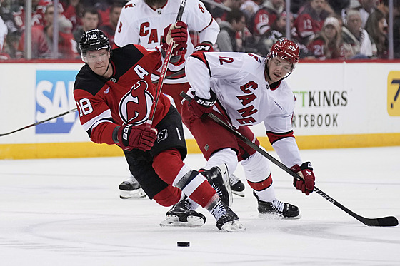 Ond�ej Palát (vlevo) z New Jersey a Jesperi Kotkaniemi z Caroliny bojují o puk.