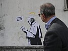 Mu� prochází kolem graffiti od um�lce Laiky, které zobrazuje pape�e Franti�ka...