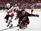 Jordan Martinook (vpravo) z Carolina Hurricanes blokuje v zápase s New Jersey...