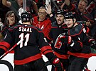 Jordan Martinook, Dmitrij Orlov a Jordan Staal slaví gól Carolina Hurricanes.