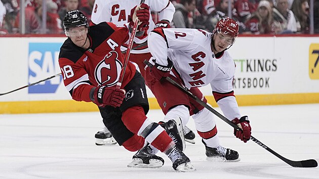 Ond�ej Pal�t (vlevo) z New Jersey a Jesperi Kotkaniemi z Caroliny bojuj� o puk.