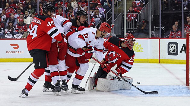 Brank�� New Jersey Jacob Markstr�m (vpravo) se ot��� za vyra�en�m pukem b�hem �tvrt�ho z�pasu s�rie proti Carolin�.