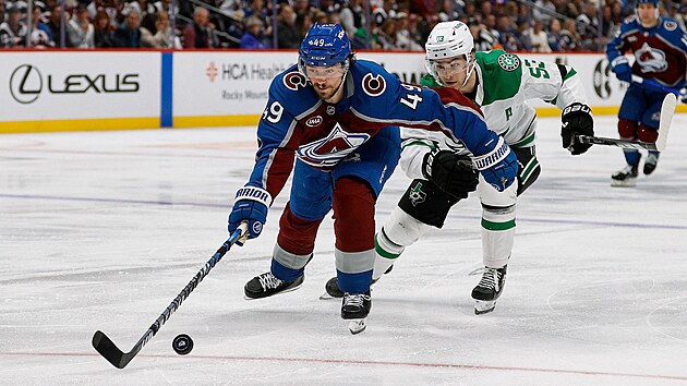 Samuel Girard (49) z Colorado Avalanche jde po puku v z�pase s Dallas Stars, st�h� ho Wyatt Johnston (53).