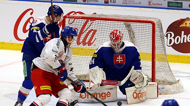 �esk� reprezentant Pavel Kousal (v b�l�m) a D�vid Mudr�k sleduj� puk, kter� vyr�� slovensk� brank�� Patrik Ryb�r.