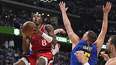 Kris Dunn z Los Angeles Clippers zakon�uje, brání Nikola Joki� z Denveru.