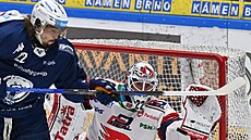 Kristián Pospíšil z Komety Brno (v modrém) operuje před pardubickým brankářem...