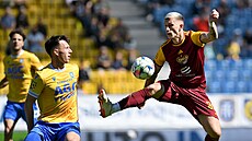 Daniel Kozma (vpravo) z Dukly Praha se sna�í zpracovat balon b�hem utkání proti...