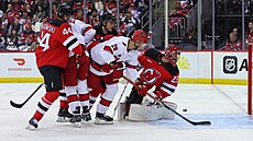 Branká� New Jersey Jacob Markström (vpravo) se otá�í za vyra�eným pukem b�hem...