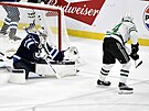 Connor Hellebuyck z Winnipeg Jets zasahuje v duelu s Dallas Stars proti pokusu...