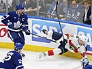 Aleksander Barkov (16) z Florida Panthers padá po faulu Austona Matthewse z...
