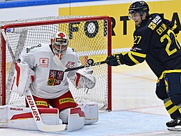 William Eklund ohrouje s pukem eskou bránu, kterou stráí Dan Vlada.