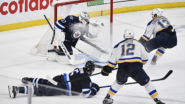 Alexej Toropenko ze St. Louis Blues sleduje, jak stela Radka Faksy kon za zdy branke Connora Hellebuycka z Winnnipeg Jets.