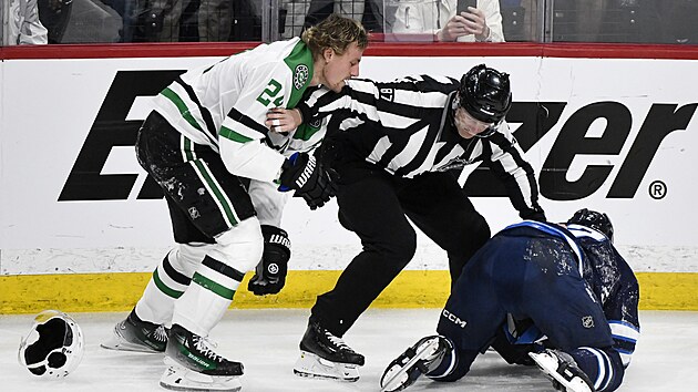 rov rozhod Devin Berg (87) od sebe tla Roopeho Hintze (vlevo) z Dallas Stars a Dylana Demela z Winnipeg Jets.