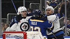Dominic Toninato (vlevo) a Nino Niederreiter z Winnipegu krotí Justina Faulka...