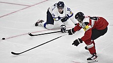Lenni Hämeenaho (vlevo) z Finska se natahuje po puku stejn� jako Gregor Biberg...