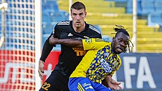 Zlínský Stanley Kanu brání v pístupu k míi Martinu Kouilovi z Varnsdorfu.