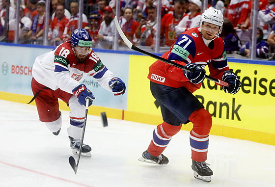 eský útoník Filip Zadina a Eskild Bakke Olsen z Norska bojují o puk.