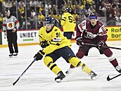 Leo Carlsson uhání s pukem p�ed Rudolfsem Balcersem.