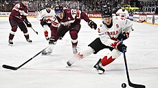 Nathan MacKinnon z Kanady vede kotou v utkání s Lotyskem.