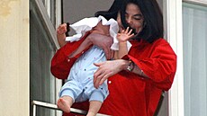Americký zpvák Michael Jackson drí své dít pes zábradlí balkonu v hotelu...